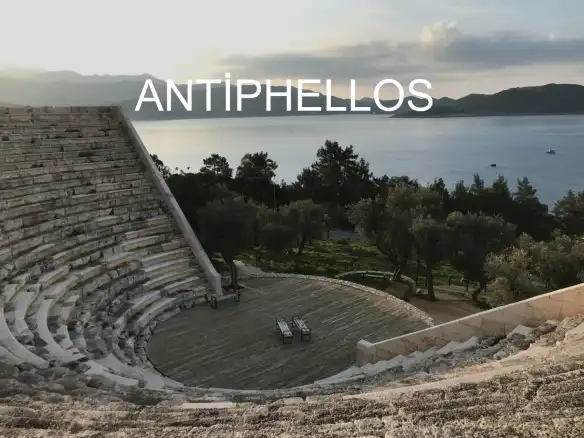 Antalya ülkemizin deniz turizmi açısından en çok tercih edilen illeri başında geliyor. Ancak yaz turizmi yanında kültür turizmini de tercih edip, tatilini bu alanda yapmak isteyenler için de sıkça tercih edilen bir destinasyon. Özellikle sınırları içinde barındırdığı Antiphellos Antik Kenti, tarih ve kültür meraklıları için unutulmaz bir deneyim sunuyor. Bu tarihi ve mimarisi ile göz alıcı yapı, Antalya’nın Kaş ilçesi sınırları içinde yer almaktadır. Antiphellos, MÖ 2. Yy’da kurulmuş olan kent, özellikle Hellenistik dönemde ticari girişimlerin desteklediği gelişmelerle yükselişe geçer ve ciddi bir liman kenti olma özelliğine kavuşur. Mimari açıdan tam bir işçilik örneği sergileyen bu antik kent, Meis yarımadası manzarasıyla da, tarihi açıdan olduğu gibi manzarasıyla da ziyaretçilerini fazlasıyla etkiliyor. Antiphellos Antik Kenti, dönemin en önemli liman kenti olması yanında bölge ormanlarından sedir ağacı ticaretini de yürütüyor olmasıyla da dönemin hem kendi kendini geçindiren hem de diğer ticari merkezler ile ilişkiler yürütmesine neden olan lokasyonu haline gelmiştir. Sizce de çok güzel değil mi, ülkemizde hem yaz, hem kış, hem kültür turizminin doyurucu nitelikte olması. Tercihiniz hangi alanda olursa olsun, birçok noktaya gidip görüp, benzersiz deneyimler yaşamanız mümkün. Kültür turizminin de, özellikle gittiğiniz yerin tarihi ve kültürel dokusunu araştırıp gidiyor ve bu deneyimi yaşıyorsanız, ölmeden önce yapılması gereken listenizdeki önemli bir maddeyi yerine getirmiş oluyorsunuz. Antiphellos Antik Kenti, gezi listenizdeki yerini hak eden benzersiz ve göz kamaştırıcı bir yer. Tarihi önemi, kültürel dokusu, deniz manzarası, etrafını çevreleyen ve oksijene doymanızı sağlayacak sedir ağaçlarının dinginlik veren hışırtısıyla, surlarda oturun gözlerinizi kapatın huzuru hissedin. Gözlerinizi tekrar açtığınızda inanın zamanda yolculuk yapmış gibi olacaksınız. Tabi bölgenin dokusunu az da olsa bilmeniz gerekiyor ki, o huşuyu tam içinizde hissedebilin. Ne yazık ki bu antik kentten günümüze gelebilen sadece Antik Tiyatro oldu. MÖ 2. Yy’da önemli bir yaşam, liman ve ticaret kentinden günümüze sadece antik tiyatro kalıntılarının zarar görmeden gelmiş olması her ne kadar üzücü olsa da, bölgenin önemini azaltmıyor. Tiyatro sapasağlam günümüze kadar dimdik ayakta gelmiş ancak Kaş’ı gezmeye başladığınızda antik kentten kalan irili ufaklı, belirli belirsiz izler göreceksiniz. Tarih Kaş’ı gezerken peşinizi bırakmayacak, buna hazırlı olun JAntik tiyatro hariç günümüze kadar tarihi yapısını koruyarak gelen bir başka eser de yine Antiphellos Antik Kenti içinde yer alan Kral Lahdi. Özellikle bölgeyi ziyaret eden turistlerin büyük ilgi gösterdiği lahit Uzun Çarşı civarında yer almakta bunun yanında Dansözler Mezarı da yine kentin dikkat çeken yapılarından biridir. Bu tarz örneklere sıkça rastlayacağımız Kaş’ın, hem yaz hem de kültür turizmi açısından zengin olması siz tatilcileri her anlamda memnun edecek.