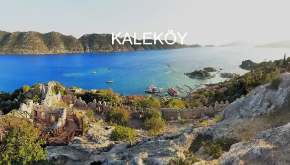 Antik Kent cenneti Antalya, eski adı Simena yeni adı Kaleköy olan şirin turistik kasabasıyla doğa tutkunlarını her yıl ağırlamakla kalmayıp kendine hayran bırakıyor. Antalya’nın Demre ilçesine bağlayan bu güzel kasabanın en değişik özelliği karada olmasına rağmen karayolu ulaşımı olmayan tek bölge. Değişik ancak Kaleköy’e özgü. Antalya kültürel ve tarihi anlamda zengin ve bu zenginlikleri destekleyen doğa mucizesi harikalarla donatılmış. Adeta lütuf gibi, şahit olduğunuz tüm manzaralar size dünya üzerindeki cennetin kapılarını ardına kadar açıyor. İster tatil yapın ister ziyaret için bölgeye gidin, memnun olmadan ayrılmayacağınızın sözünü veriyor size Antalya her anlamda. Kaleköy ise bambaşka bir pencereyle sizi kucaklıyor. Tarihi çok köklü, kültürel mirası paha biçilemez, denizi alabildiğince mavi, mistik havası ise alışkanlık yaratıcı. Peki siz bir tatilden daha başka ne beklersiniz? Kaleköy çok geniş bir alanı kaplayan Kekova Çevre Koruma alanında kendine yer bulmuş arkeolojik bir sit alanı aynı zamanda. Bölgede lahitler, kaleler, taş merdivenler, iskele kalıntılarının sizi karşılaması daha ilk andan itibaren antik çağa tüm izleri beğeninize sunuyor, hayranlıkla. Kaleköy her ne kadar sit alanı olup antik çağ kalıntılarına ev sahipliği yapsa da, yaz turizmi açısından da tatil meraklılarını ağırlamaya hevesli alternatifler sunuyor. Türkiye’nin çoğu köşesi ölmeden görülecek cennetler listesinde, Kaleköy ise cennetin ta kendisi; doğa cenneti, temiz hava cenneti, manzara cenneti, kültür cenneti, tarih cenneti… Kekova denilince akla ilk gelen bölge olan Kaleköy’ün en dikkat çeken özelliklerinden biri, denizinde yükselen büyüklü küçüklü ada ve adacıklar. Manzarayı Kaleköy’in, yeşilin her tonunu cömertçe sergilediği tepelerinde izlerseniz, mavi enginlik içinde yeşil yosunların aksini, adaların doyurucu görsel şovunu bizzat tanıklık edeceksiniz. Tatile çıkmadan önce yapmak istediğiniz tatil tipine karar vermeniz daha iyi olacaktır hayal kırıklığı yaşamamamız adına. Ancak rotanız Kaleköy ise aklınızda soru işaretleri olmadan yola koyulabilirsiniz. Hem dinlenip, hem öğrenip, hem gezebileceğiniz ve hepsini aynı yerde yapabileceğiniz nadir bir destinasyon olan Kaleköy’de, sabahları korna seslerine inatla kuş cıvıltıları ve balıkçı motorlarının güne başlayan sesiyle uyanacaksınız. Kahvenizi hazır soğutmadan camınızı aralayın, huzur dışarda sizi bekliyor… Deniz kenarındaki şirin ve renkli rum evleriyle bir bölgede tatil yapıyorsanız aç kalmayacaksınız demektir. Denizle iç içe geçmiş balık restoranları, sadece balık değil denize ait tüm meze ve canlılarla zenginleştirecek masanızı. Kaleköy’de lüks ve çok yıldızlı otel aramayın, rahat ve temiz pansiyon ve butik oteller ağırlayacak sizi tatilinizde. Zaten manzarayı bırakıp uyumak bile istemeyeceksiniz neredeyse. Her anlamda doğal olmasıyla dikkat çeken Kaleköy, yerli halkın el işçilikleriyle hazırladıkları dantel, yazma, örgü gibi değişik eşyaları açtıkları tezgahlardan kendinize Kaleköy hatırası satın alabilirsiniz. Pişman olmayacağınız bir tatil hazırlığı yapmaya başlasanız fena olmaz, nedersiniz?